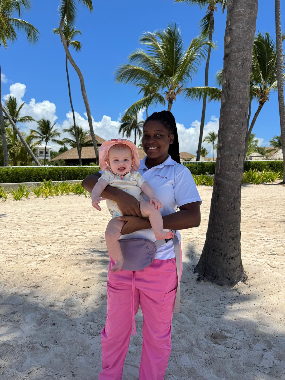 Babysitter PRO nanny holding a baby on the beach